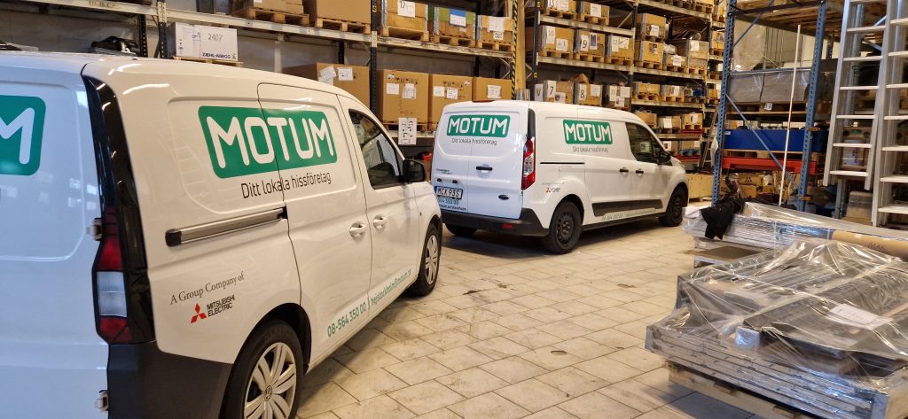 Flera folierade servicebilar från Motum uppställda efter montering i Stockholm